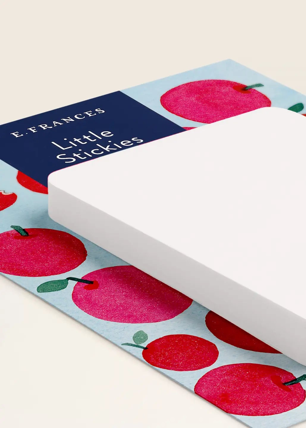 White sticky notes on a blue mat with red apples, branded 'E-Frances Little Stickies'.