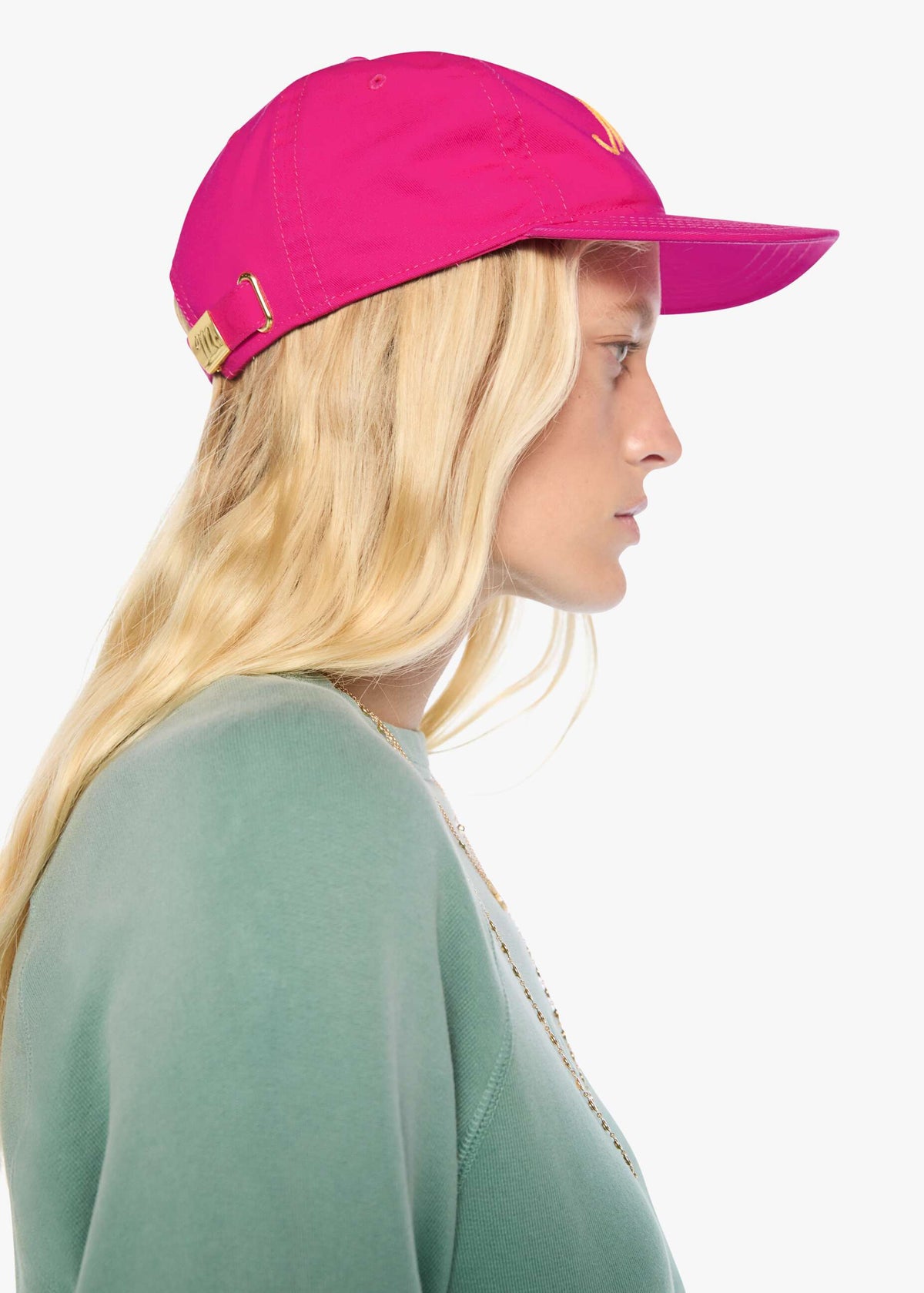 Person wearing a bright pink cap with a logo on a white background