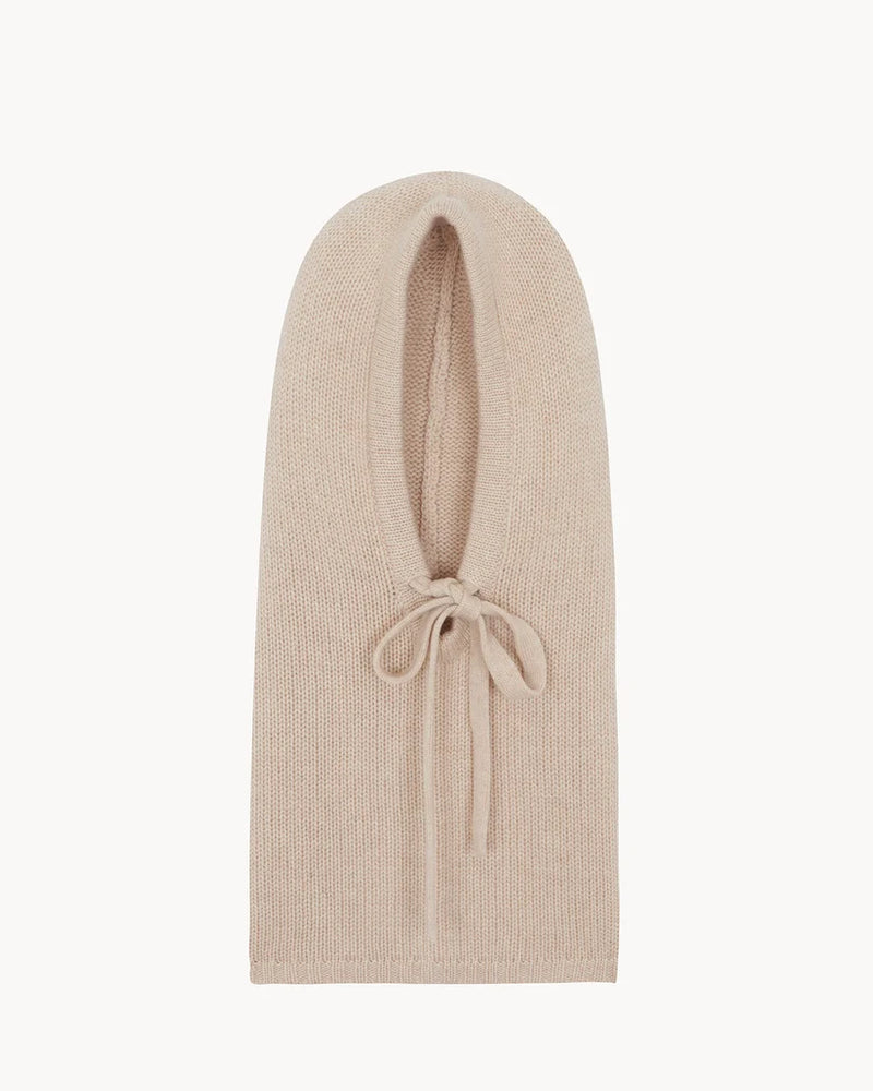 A light beige knit balaclava or neck gaiter with a small tie detail at the front, shown flat against a solid white background.