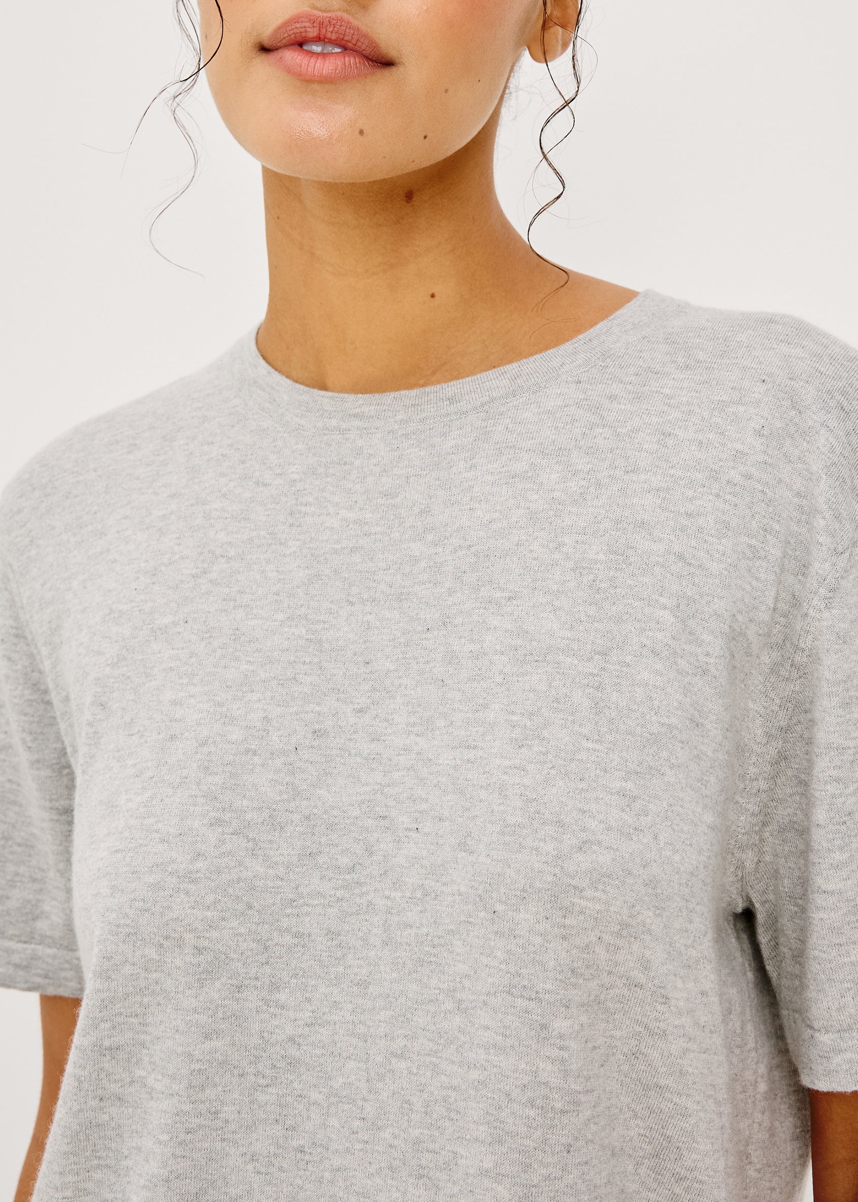 Person wearing a gray t-shirt on a plain background