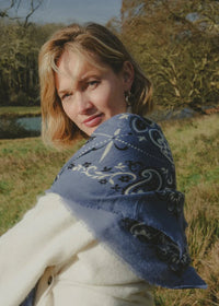 Woman wearing a blue patterned shawl in a natural setting