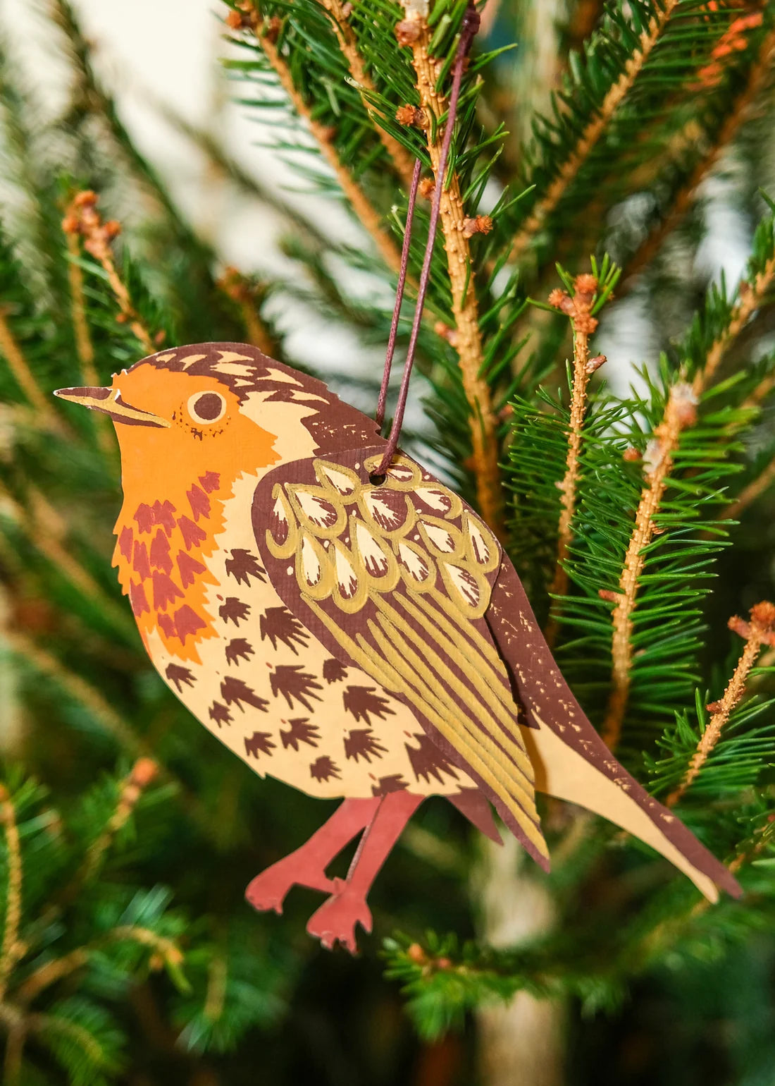 Decorative bird ornament hanging on a Christmas tree.