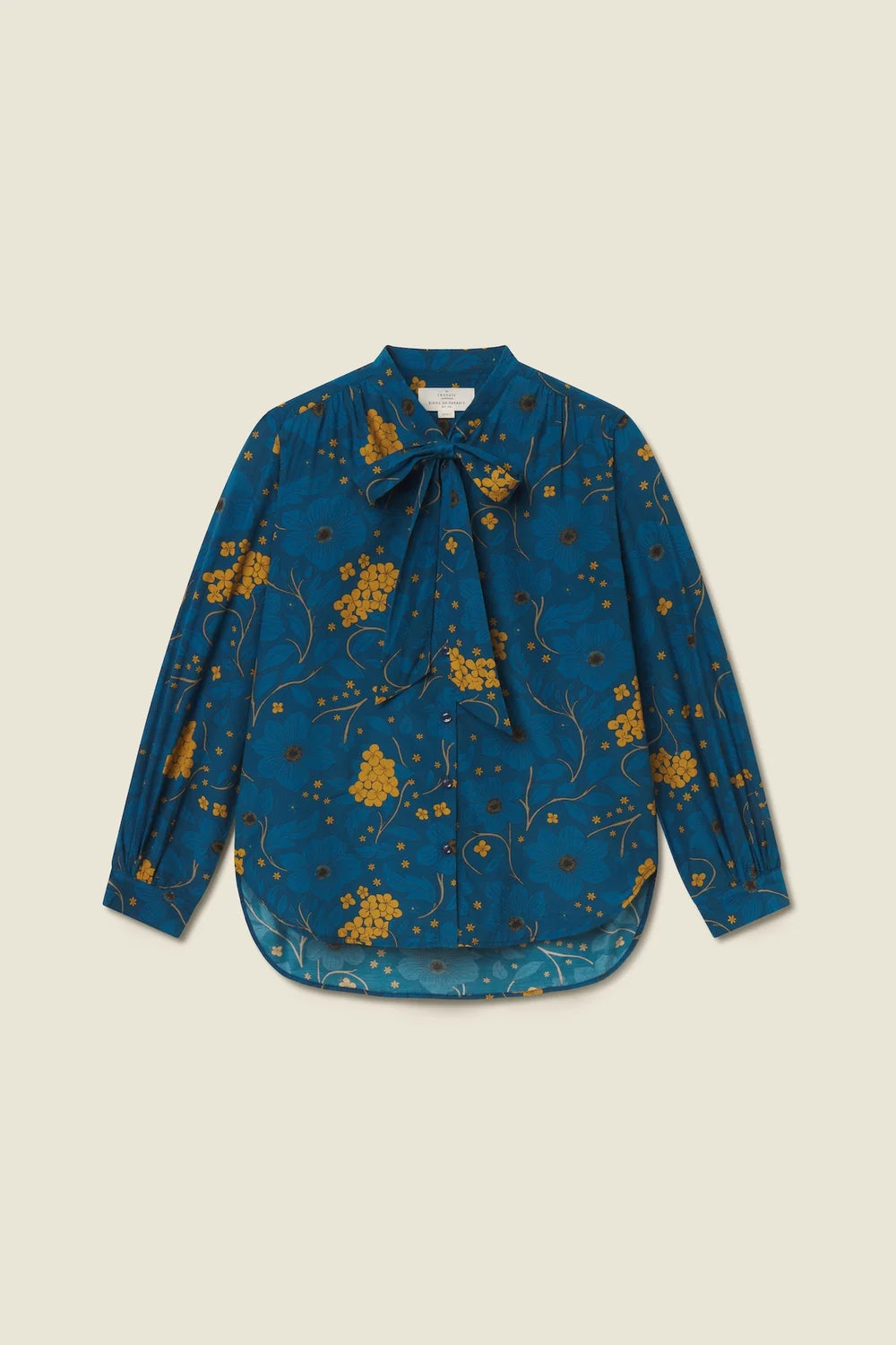Blue floral blouse with a bow tie on a beige background