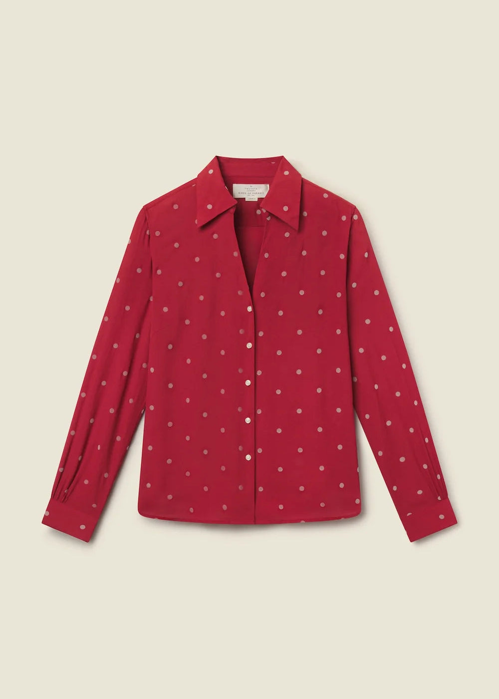 A red long-sleeve button-up shirt with a small white polka dot pattern, displayed flat against a light beige background.