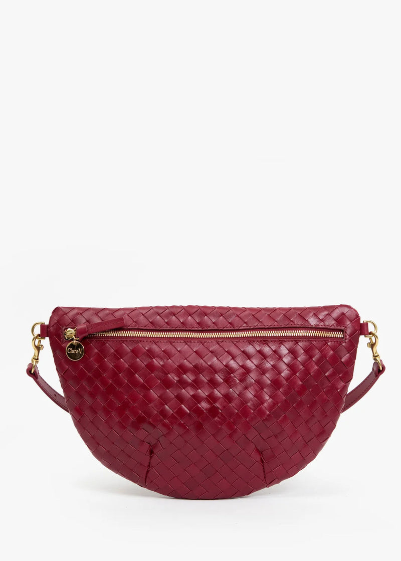 A burgundy woven leather half-moon waist bag with gold-tone hardware and a zippered front, shown against a plain white background.