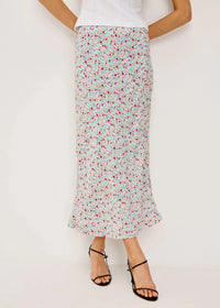 Person wearing a floral skirt on a plain background