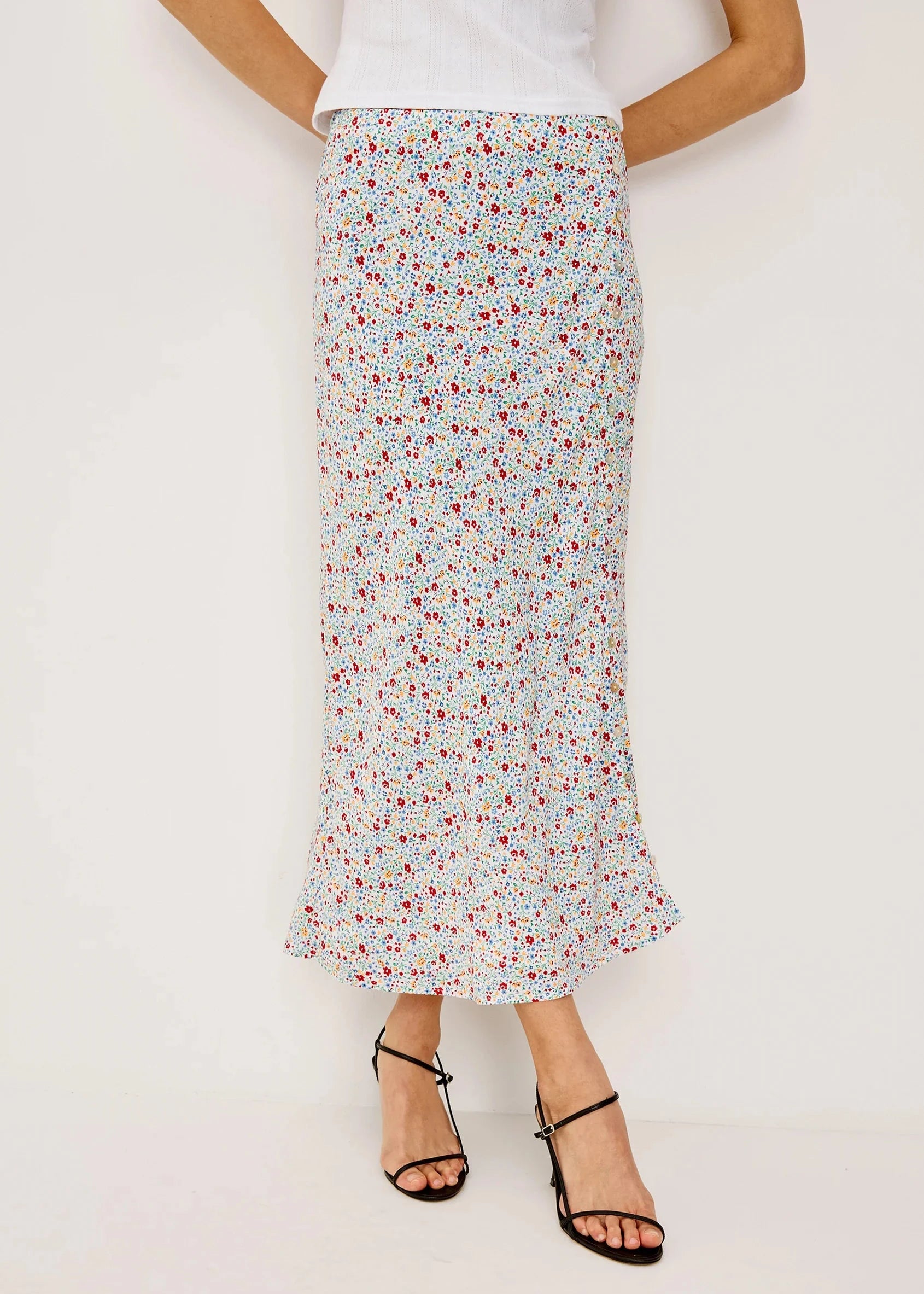 Person wearing a floral skirt on a plain background