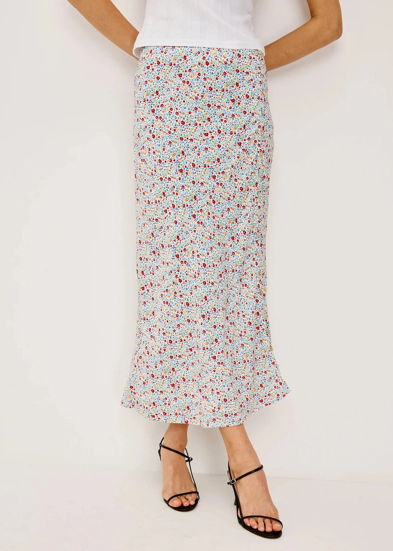 Person wearing a floral skirt on a plain background