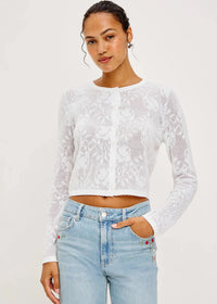 Woman wearing a white lace top and light blue jeans on a white background