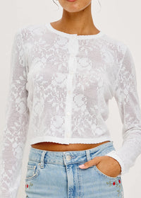 White lace long-sleeve top worn by a person with a white background