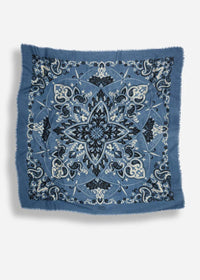 A square blue bandana with a detailed black and white paisley and floral mandala pattern, featuring frayed edges, shown against a light gray background.