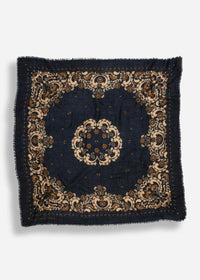 A square dark navy blue scarf with an ornate beige and brown traditional floral pattern and frayed edges, displayed flat against a light gray background.