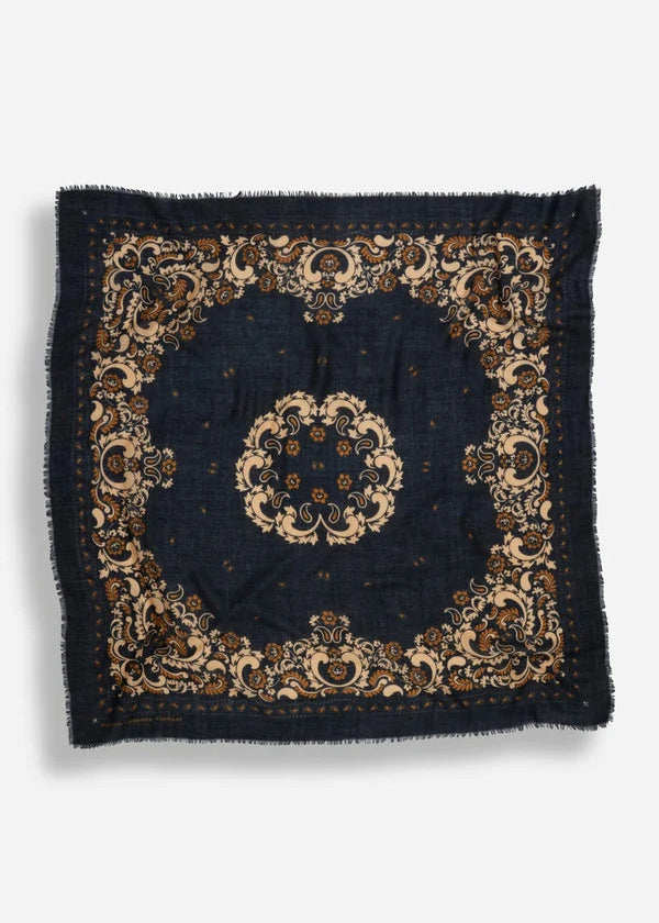 A square dark navy blue scarf with an ornate beige and brown traditional floral pattern and frayed edges, displayed flat against a light gray background.