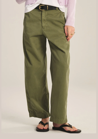 Person wearing olive green pants on a plain background