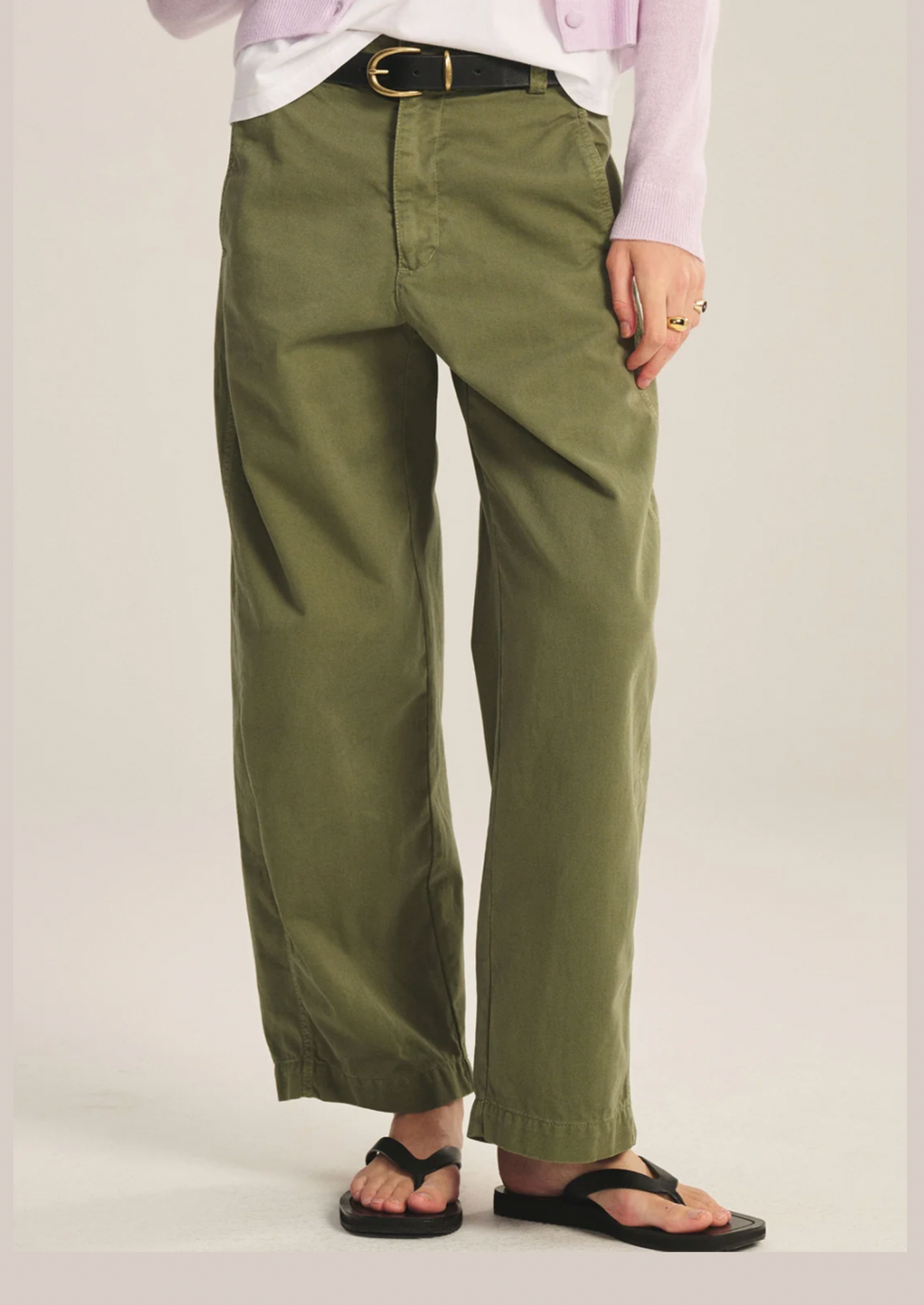 Person wearing olive green pants on a plain background