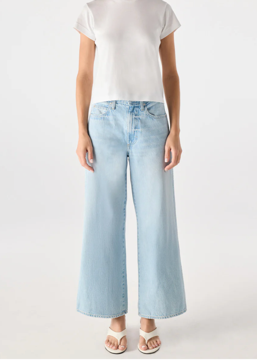 Person wearing a white t-shirt and light blue jeans on a white background