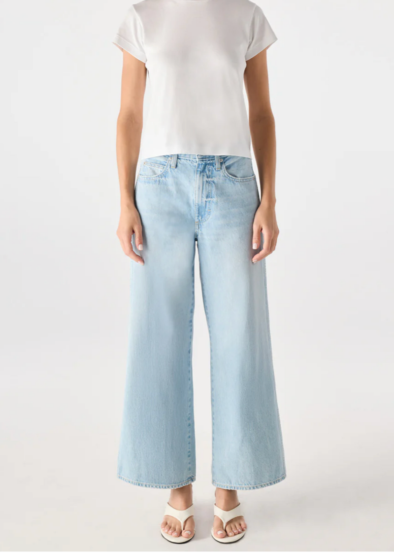 Person wearing a white t-shirt and light blue jeans on a white background