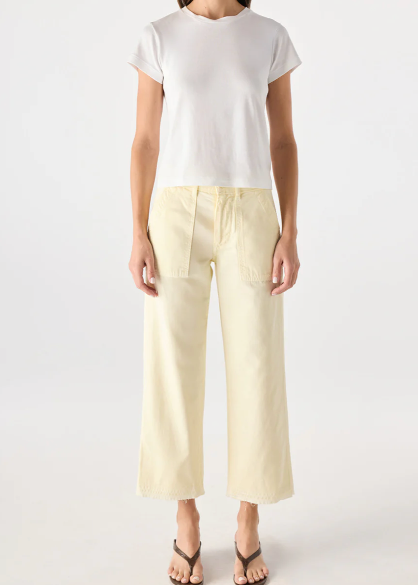 Person wearing a white top and light yellow pants on a white background
