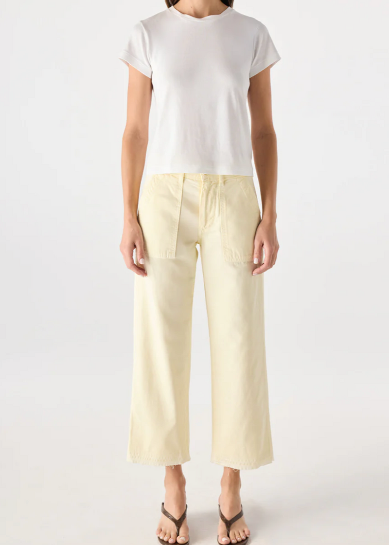 Person wearing a white top and light yellow pants on a white background
