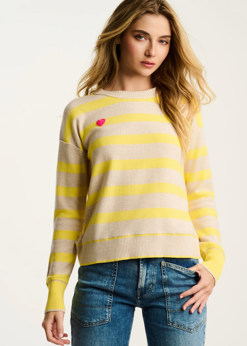 Woman wearing a yellow and beige striped sweater with a red heart on a white background