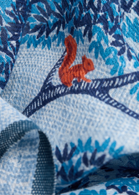 Close-up of fabric with a red squirrel design on a blue and black patterned background