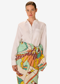 Woman wearing a white shirt and colorful patterned skirt on a white background