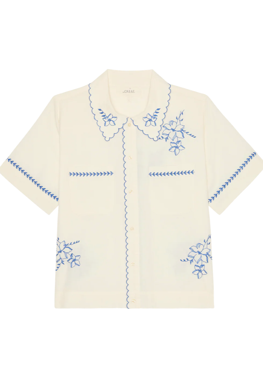 White shirt with blue embroidery on a white background