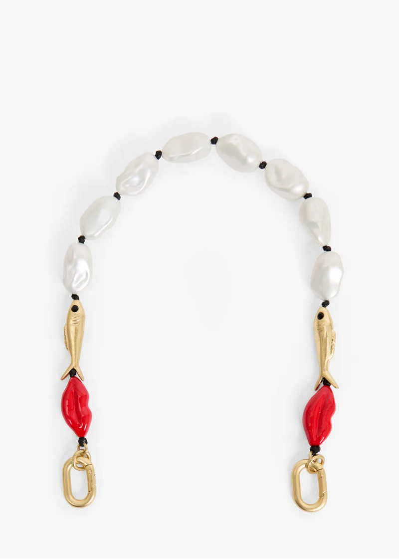 A beaded necklace featuring irregular white baroque pearls, small black beads, gold-tone fish charms, and bright red lip-shaped beads, finished with gold-tone lobster clasps on a white background.