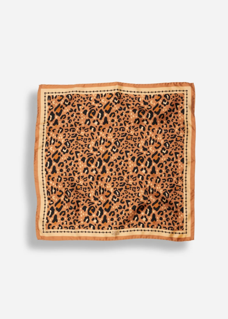 A square scarf with a leopard print pattern in shades of brown, black, and tan, finished with a solid tan border and stitched edges, shown flat against a light gray background.
