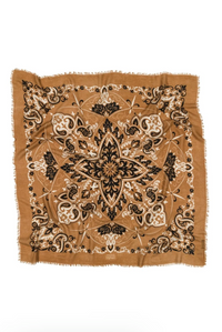 A square scarf with fringed edges, featuring an intricate symmetrical mandala and paisley pattern in black, beige, and brown on a tan background, laid flat against a white background.