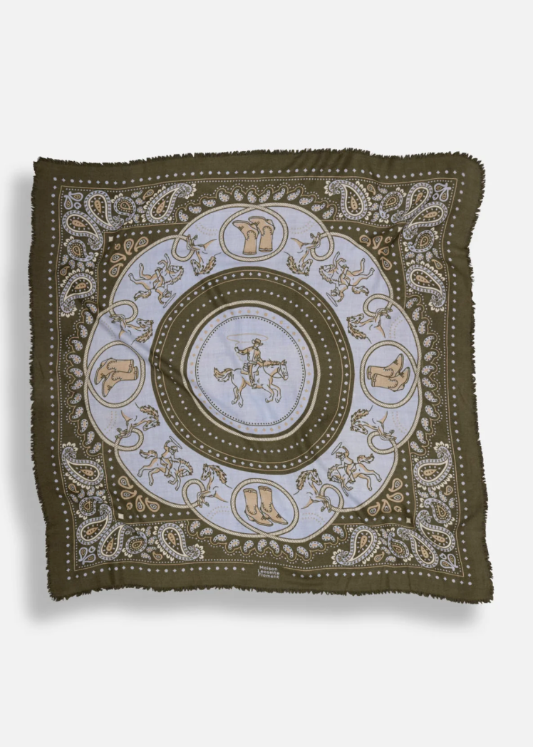 A square scarf with fringed edges featuring a circular western-themed paisley pattern in olive green, cream, and tan.
