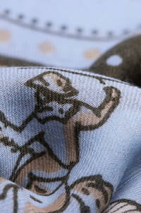 Close-up of a light blue knit fabric with a cartoon-style printed pattern in beige and dark brown outlines.