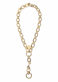 A gold chain necklace with a unique Y-shaped arrangement, featuring a central round charm, a short section of chain, and a long drop chain ending in a large ring, shown on a plain white background.