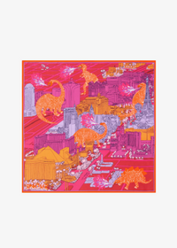 A square silk scarf featuring a vibrant pop-art illustration of dinosaur figures traversing a futuristic cityscape. The design is dominated by hot pink and orange, with white and light purple details, framed by a thin orange border on a clean white background.