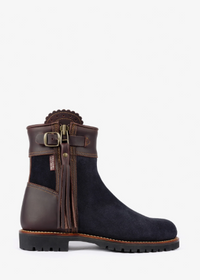 A dark brown and navy blue ankle boot with a side zipper, leather strap with a buckle, and a tassel detail, shown against a plain white background.