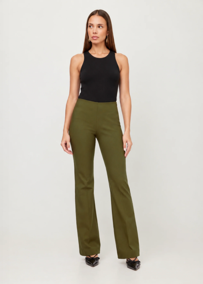 A woman modeling a black sleeveless ribbed tank top and olive green wide-leg trousers against a light gray studio background.