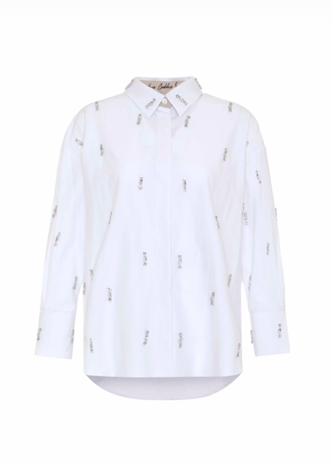 A white long-sleeve button-up shirt with a pointed collar, featuring a subtle all-over repeating pattern of small vertical text and photographed on a plain white background.