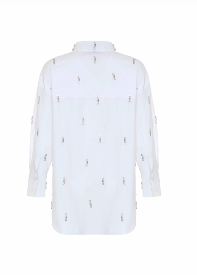 A white long-sleeve button-up shirt shown from the back, featuring small metallic embroidered figures spaced vertically across the fabric.