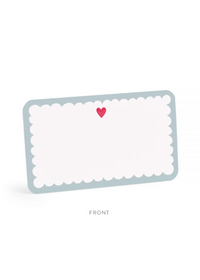A scalloped rectangular card or label with a pale blue border, white center, and a small pink heart near the top, shown on a light gray background with the word FRONT below.
