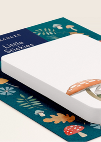 A white rectangular pad of Little Stickies sticky notes placed on top of a decorative teal paper mat with illustrated mushrooms, leaves, and autumn leaves. The brand name 'Frances' and product name 'Little Stickies' are visible on the top-left corner of the mat.