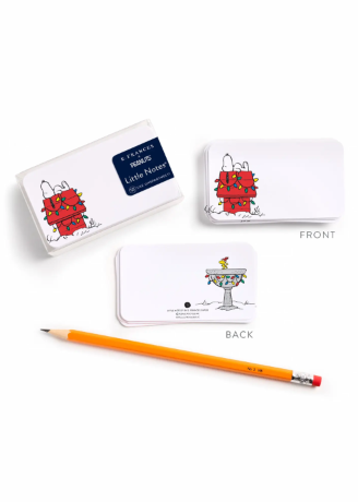 A set of Snoopy-themed cards shown on a white background, with the front and back views displayed alongside a yellow pencil. The packaging and card sleeves feature illustrations of Snoopy and a red gift box, with the back showing a small Snoopy graphic on a white card.