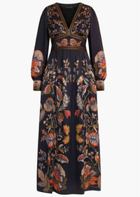 A long-sleeved maxi dress in black with an intricate multicolor floral and botanical print, featuring gold embroidered detailing around the neckline and waist, shown against a plain white background.