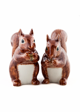 Two ceramic squirrel figurines in reddish-brown and white glaze, standing side by side against a plain white background.
