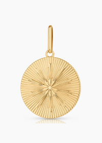 A gold round pendant charm with a textured sunburst or radial line pattern, featuring a polished bail at the top, shown on a clean white background with a subtle reflection below.