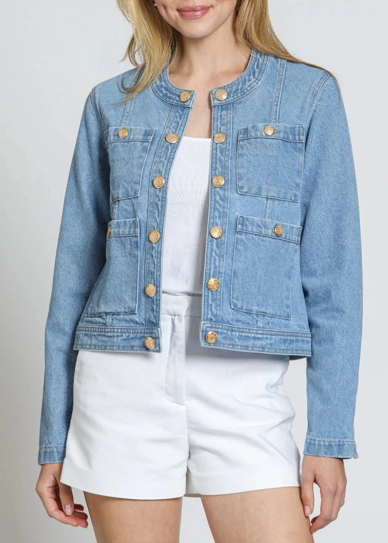 Denim jacket with gold buttons worn by a person on a plain background